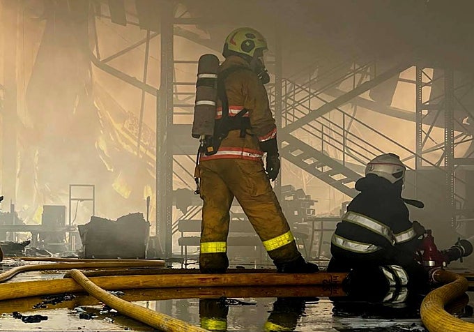 Varios bomberos sofocan un incendio en un almacén ucraniano