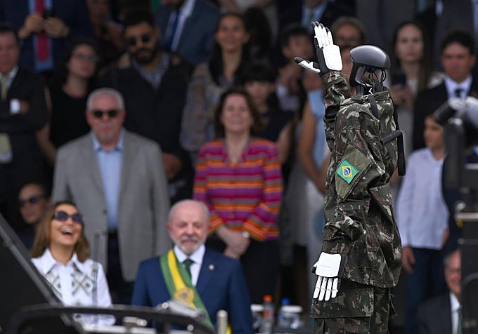 Un robot vestido con el uniforme de las Fuerzas Armadas de Brasil saluda al mandatario brasileño