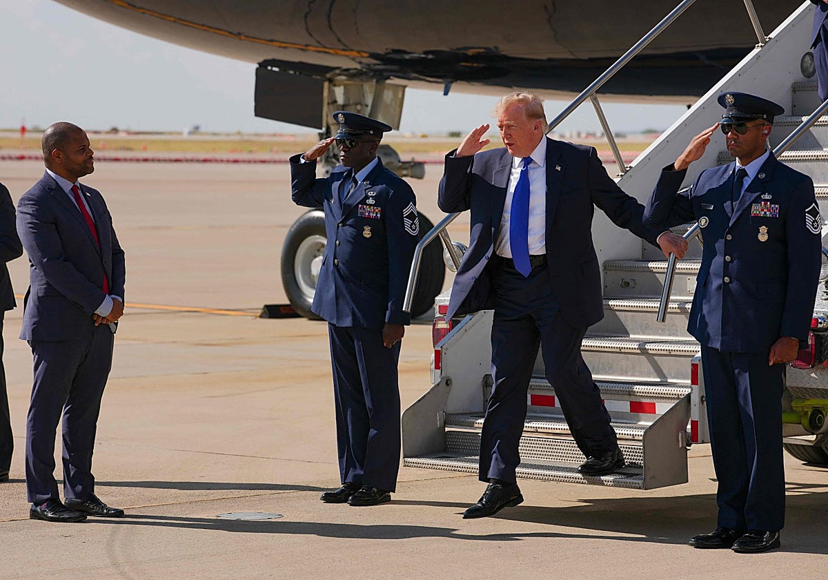 Trump saluda militarmente al alcalde de Dallas, Eric Johnson, tras desembarcar del Air Force One