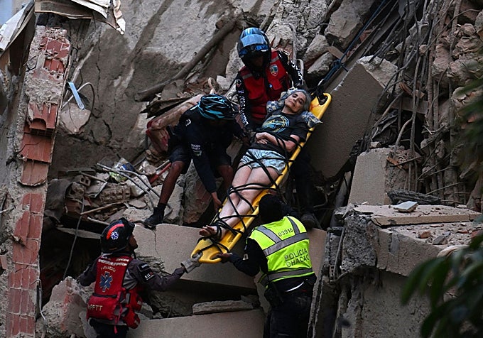 Los equipos de rescate trasladan a una víctima del derrumbe en uno de los edificios en Caracas.