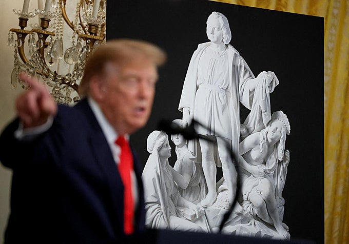 La fondo se puede ver otra de las esculturas de Colón recuperadas., mientras Trump habla durante el acto