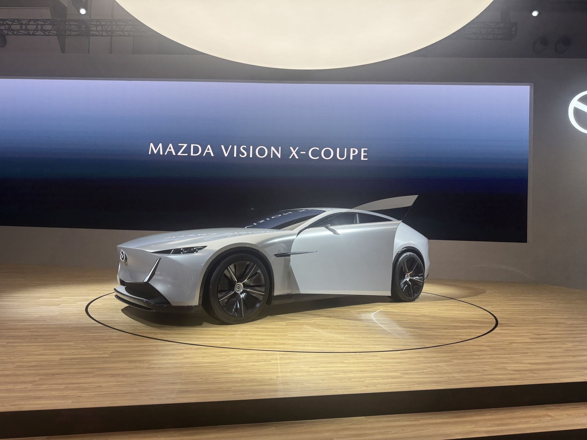 Mazda, la marca de Hiroshima muestra una estrategia dual: preservar la esencia de la conducción («joy of driving») mientras avanza hacia la sostenibilidad. Entre las novedades desvelan dos modelos conceptuales bajo la denominación Mazda Vision‑X Coupe y Mazda Vision‑X Compact. El primero es un crossover coupé plug-in-híbrido que desarrolla aproximadamente 503 bhp, con autonomía eléctrica estimada en 160 km y alcance combinado de unos 800 km. El segundo, más pequeño, está orientado a la interacción humano-vehículo mediante inteligencia artificial empática («empathetic AI») y propicia una nueva relación entre coche y conductor. También muestran el nuevo Mazda CX‑5 (especificación europea) por primera vez en Japón, junto con tecnología de captura de CO₂ y combustibles neutros derivados de algas, como parte de su visión a 2035.
