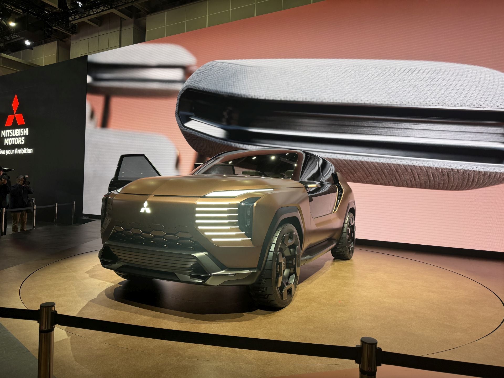 La marca japonesa Mitsubishi Motors aprovechó el JMS 2025 para presentar su visión de movilidad centrada en la aventura, con nuevos conceptos, modelos kei-car y tecnologías híbridas. Presentó el Mitsubishi Elevance Concept, un crossover SUV electrificado de estreno mundial que combina el diseño urbano con capacidades de todoterreno y un interior pensado para una experiencia confortable de viaje («glamping»). También se mostró el All‑New Delica Mini, un «super height-wagon» kei-car (categoria microvehículo japonesa) que hereda el nombre Delica y que se perfila como un compañero urbano-activo, con cinco modos de conducción recién añadidos. Bajo el tema del stand «Forever Adventure», Mitsubishi configuró un entorno de exhibición inmersivo que simula un paisaje desértico, incluyendo efectos sensoriales y experiencias interactivas para conectar con el espíritu de la exploración.
