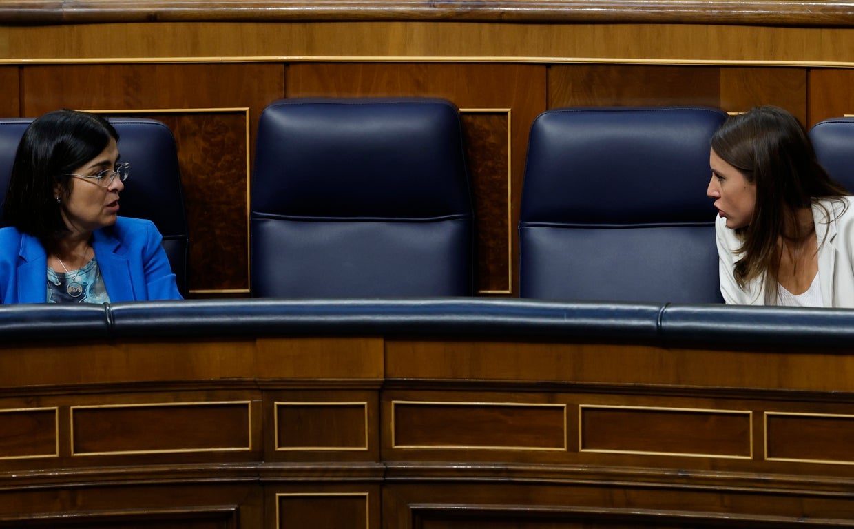 La ministra de Sanidad, Carolina Darias, conversa con la ministra de Igualdad, Irene Montero, durante el pleno celebrado, este jueves, en el Congreso de los Diputados