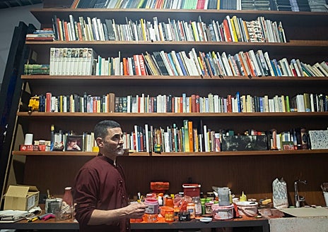 Imagen secundaria 1 - Arriba, el pintor acaricia a su perro Metta, protagonista de su políptico. Sobre estas líneas, Garcerá frente a su inmensa biblioteca. A la derecha, explicando la pieza