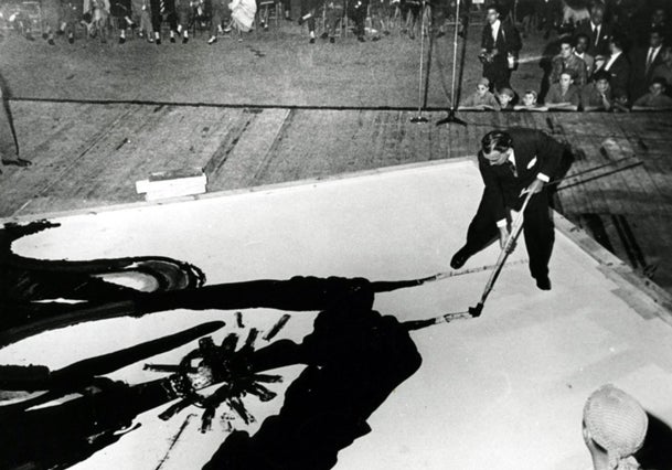 Dalí pintando con alquitrán un perfil de la Sagrada Familia.