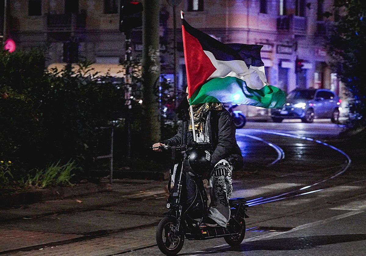Un motorista porta en Turín una bandera palestina