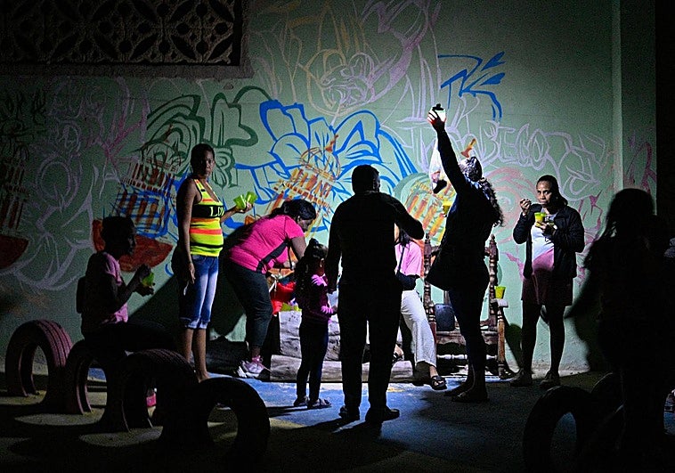 Un grupo de cubanos alumbrado por linternas