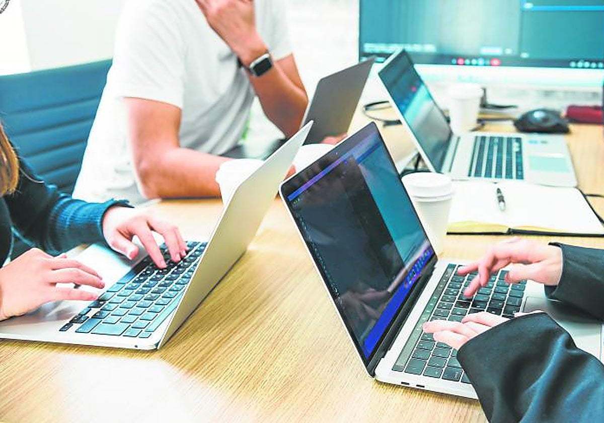 Varias personas trabajan con un ordenador en una oficina