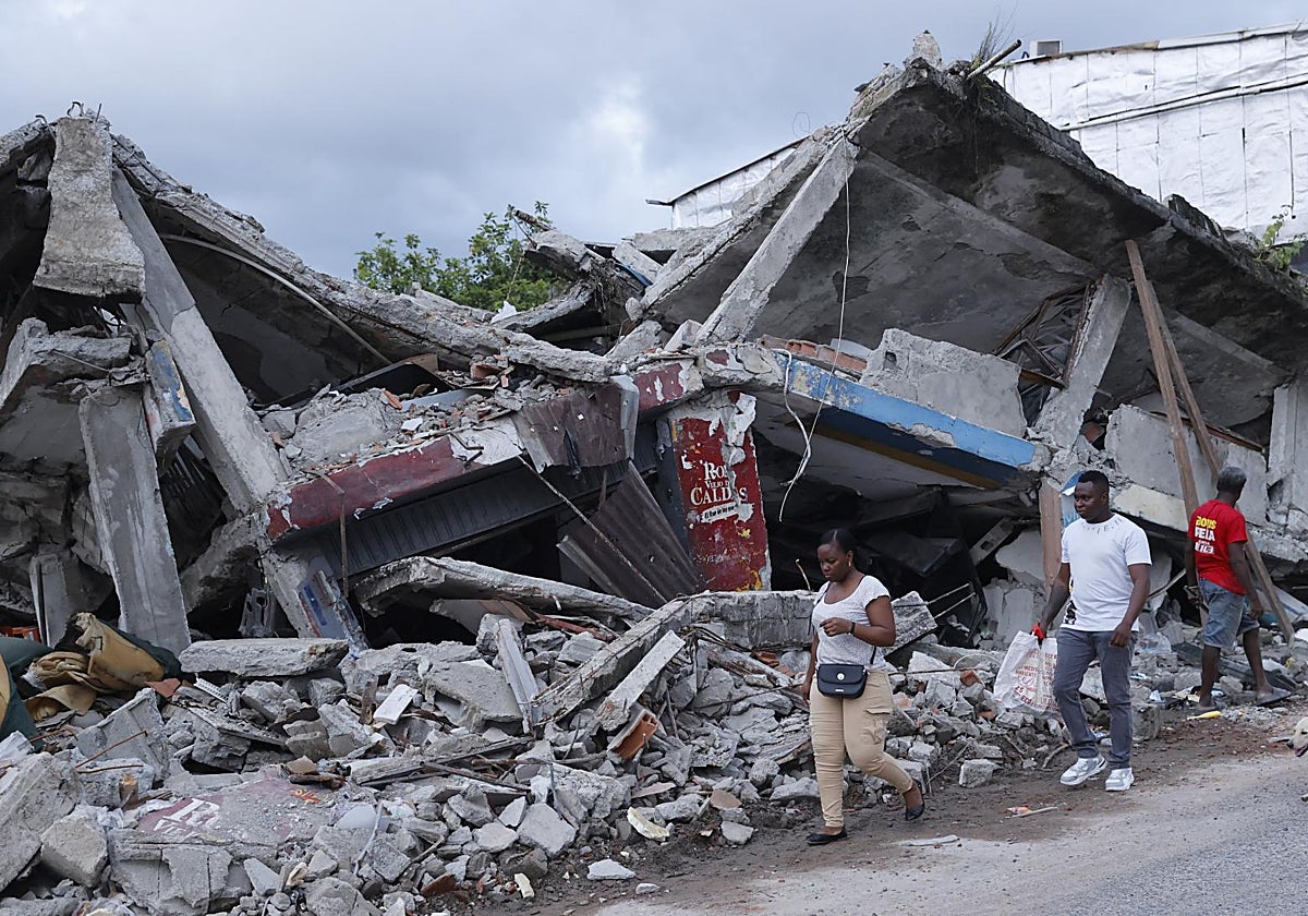 Unos venezolanos caminan frente a un edificio destruido por el terremoto, en Quibdó