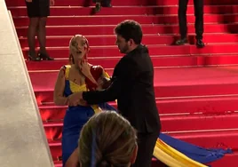 Una mujer vestida con los colores de Ucrania se vierte sangre falsa en Cannes