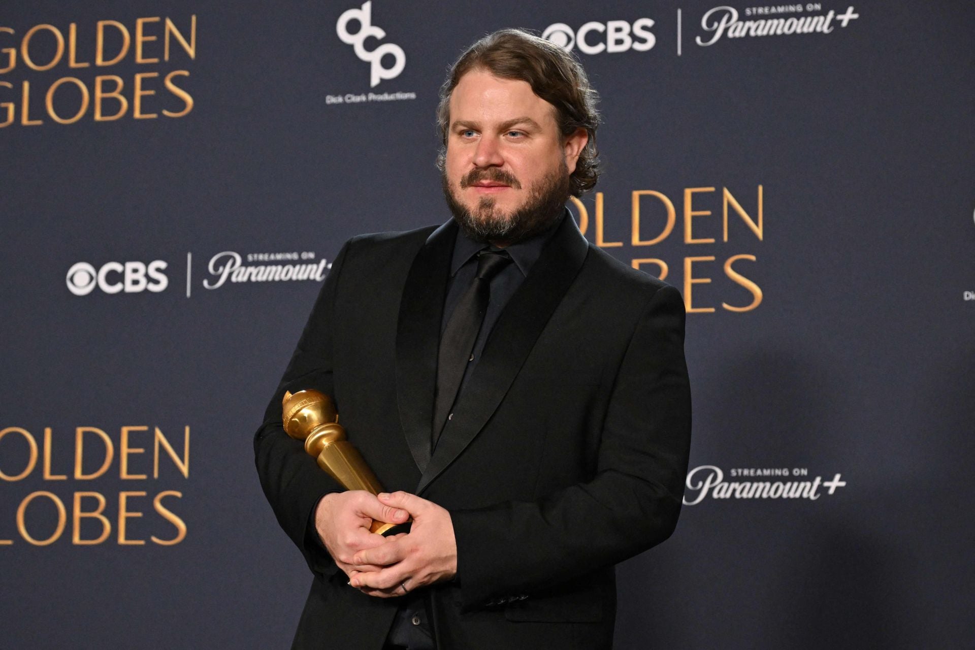 El director Brady Corbet posa con uno de los Globos de Oro que logró su película 'The Brutalist'.