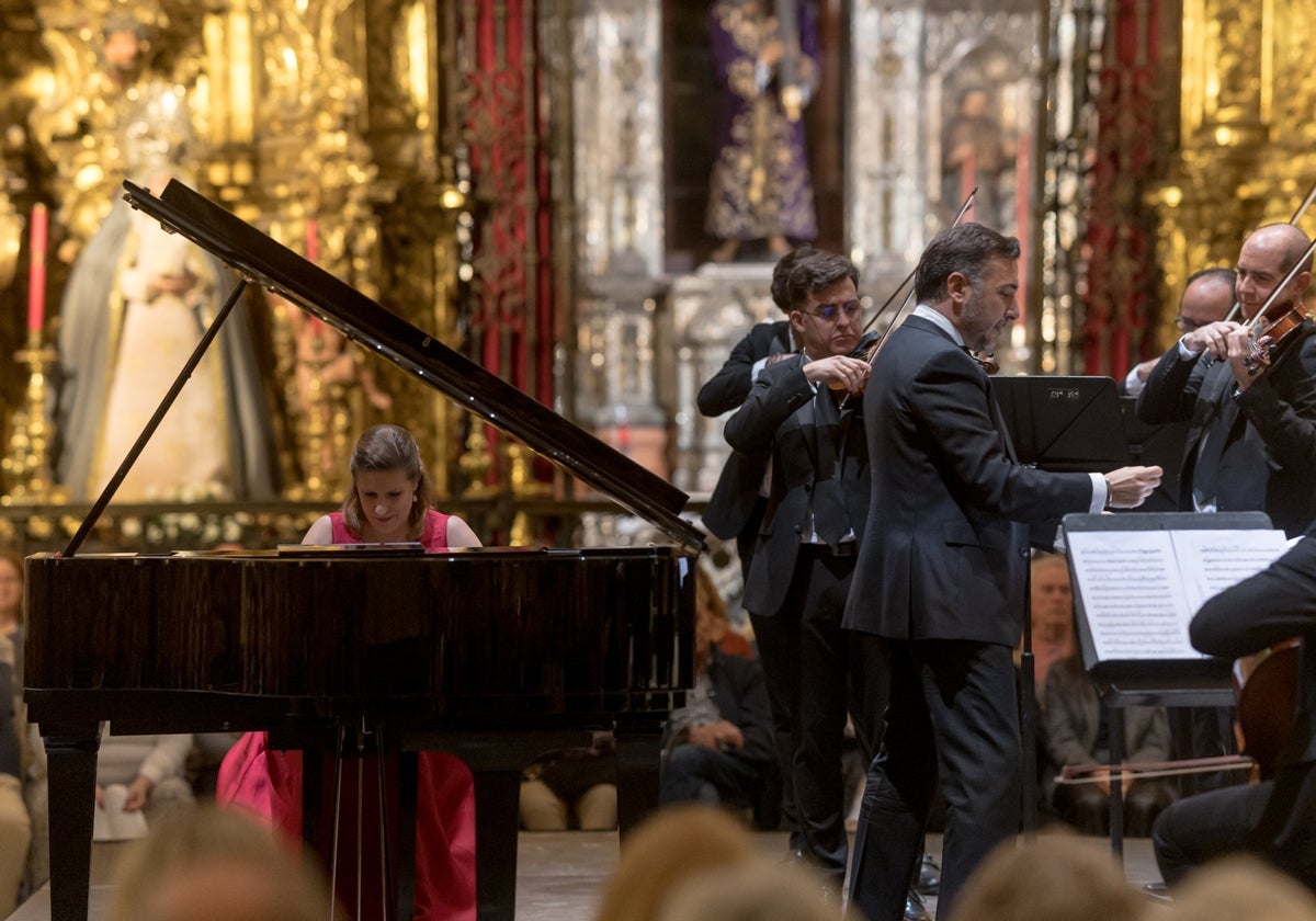 Cristina Lucio-Villegas (piano) y Rafael Ruibérriz (director(', con el Señor de Pasión al fondo