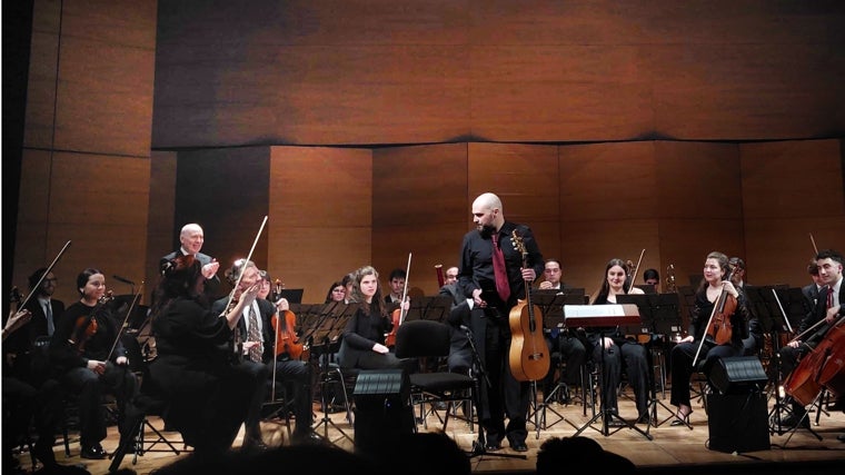 Santiago Lara (guitarra) saluda tras su actuación, con el aplauso de OBC y su director, Michael Thomas)