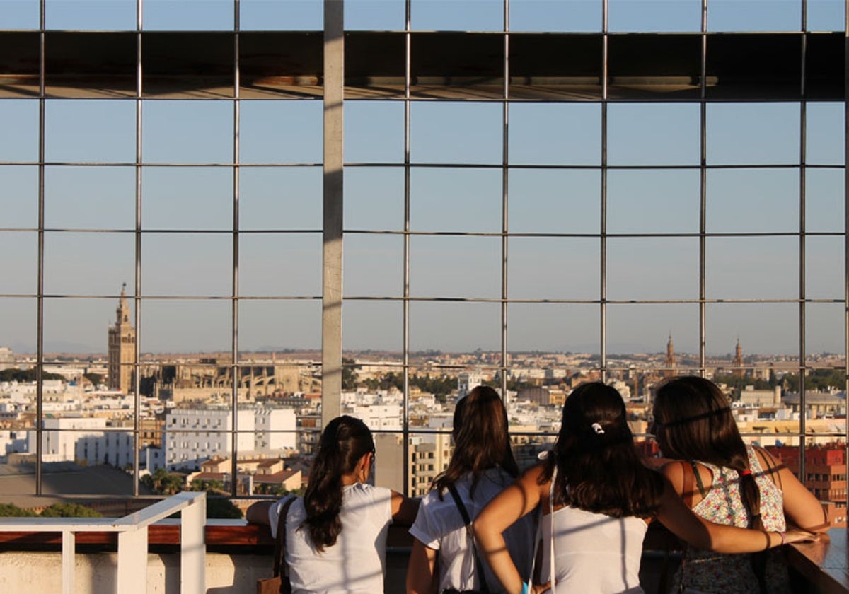 Un grupo de niñas observa la silueta de Sevilla desde la Torre Mirador del Pabellón de la Navegación