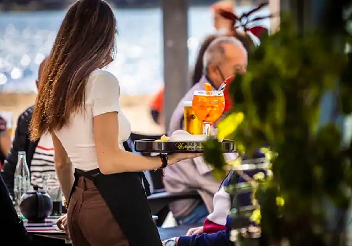 Una camarera atiende una terraza