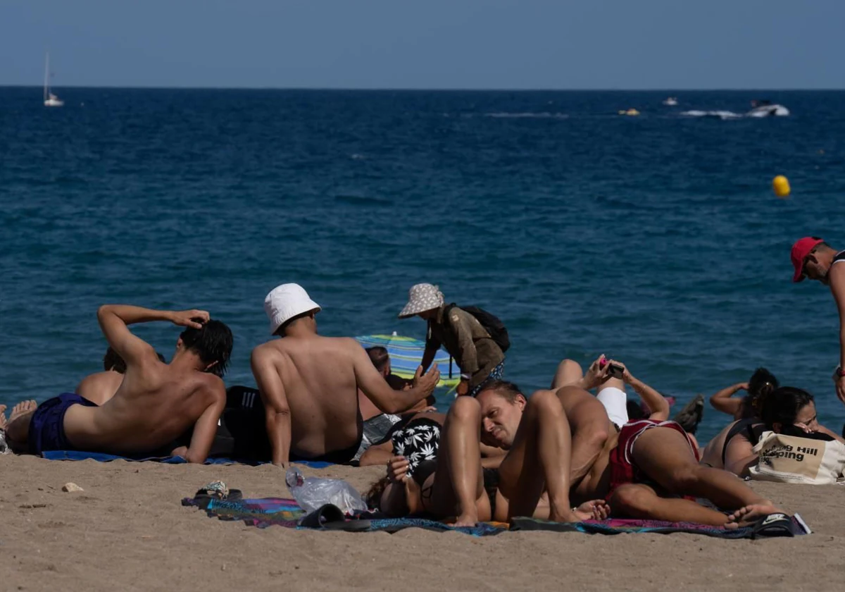 Varias personas tomando el sol hace unos días en una playa de Barcelona