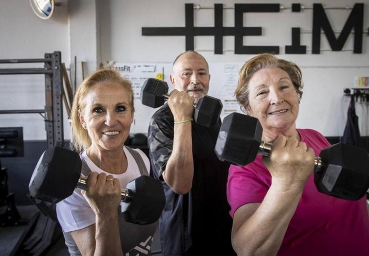Paqui, Antonio y Angustias, atletas senior, durante un entrenamiento de fuerza en CrossFit HEiM, en Pinto (Madrid).