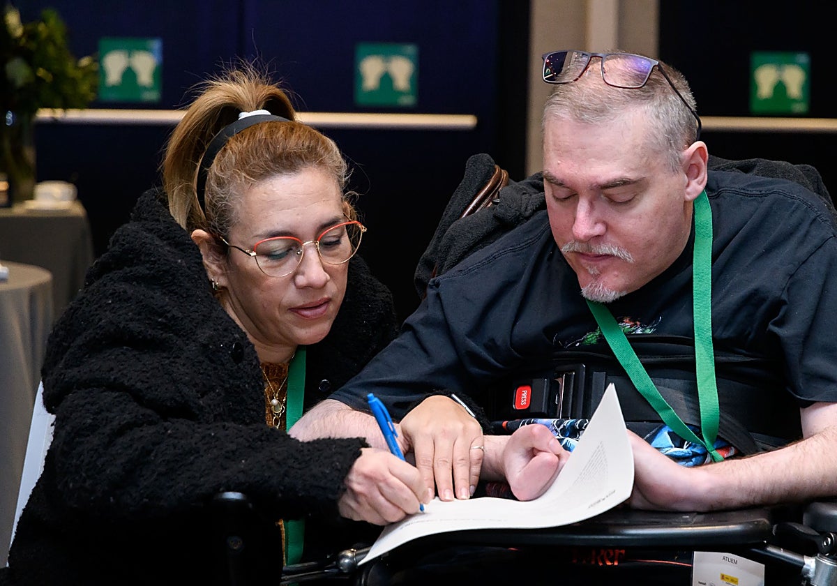 Juan José Martín, quien vive con Esclerosis Múltiple, junto a Mélida, su cuidadora.