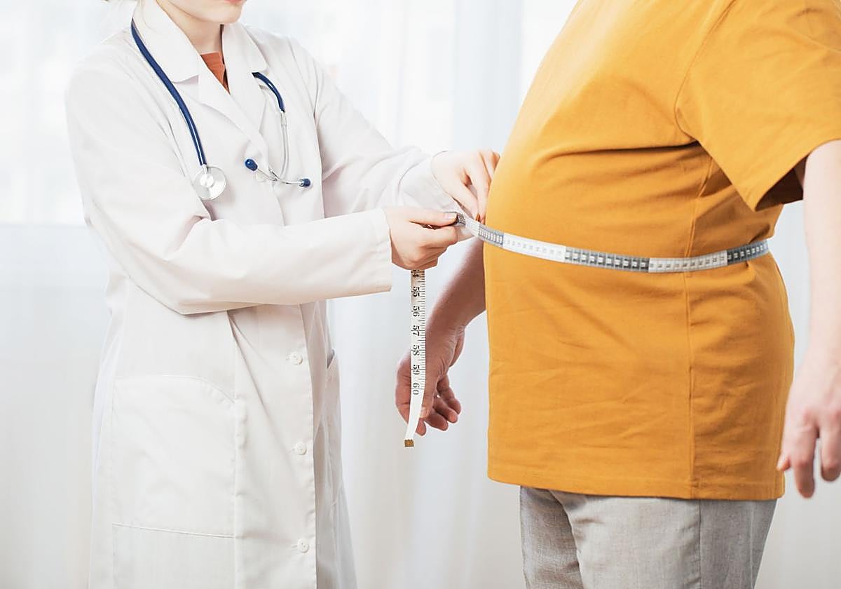 Un médico evalúa a un paciente con sobrepeso