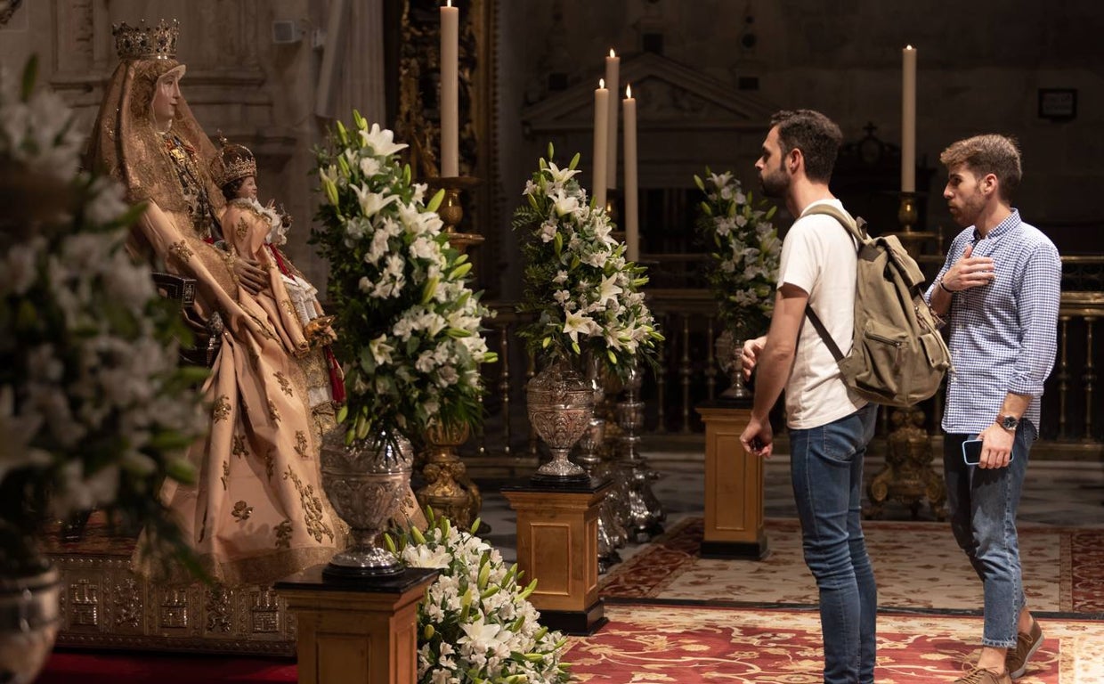 Varios jóvenes frente a la Virgen de los Reyes