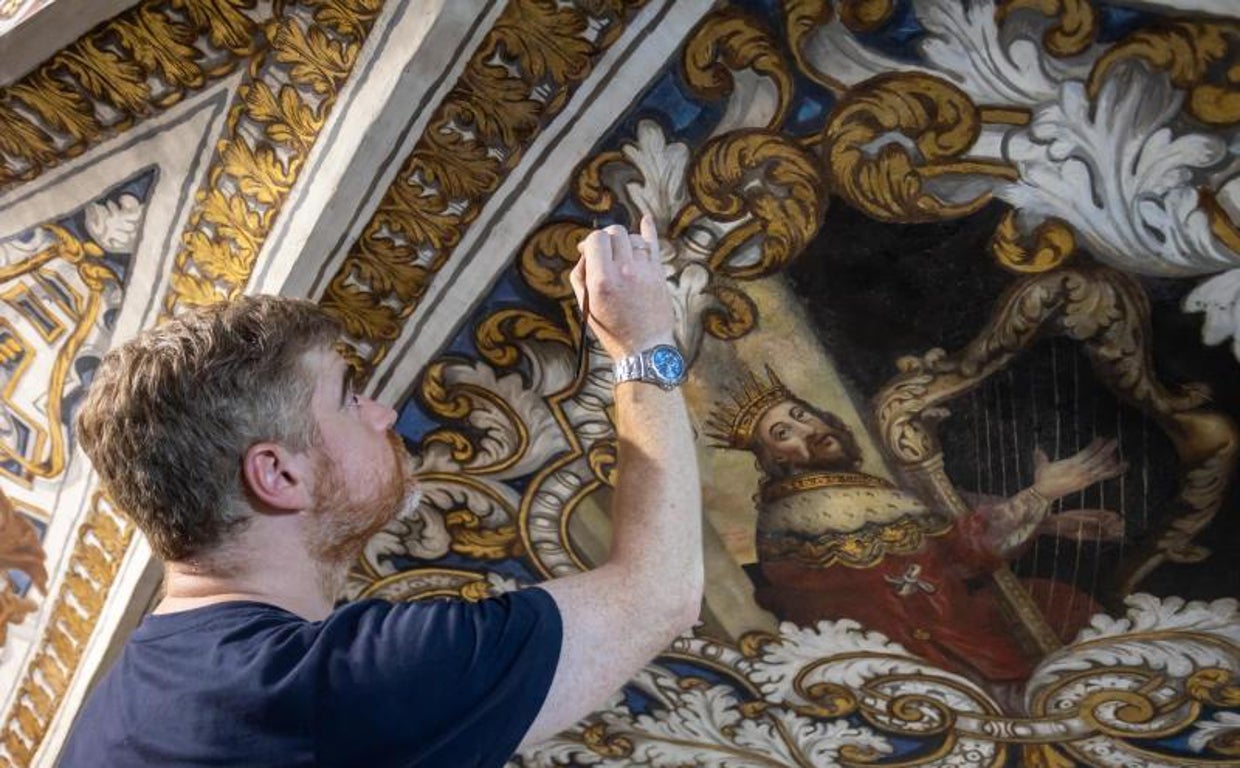 El director de la restauración, Carlos Peñuela, en una de las pinturas murales recuperadas y que se encuentra debajo del órgano