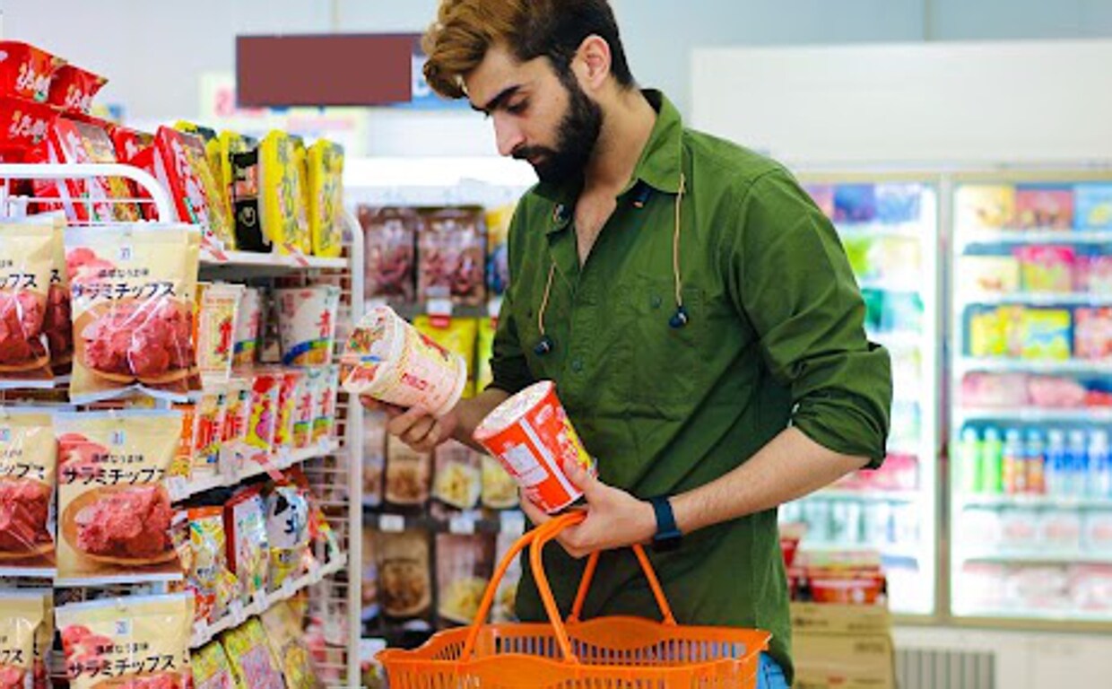Un joven consulta el valor energético de un producto en el supermercado