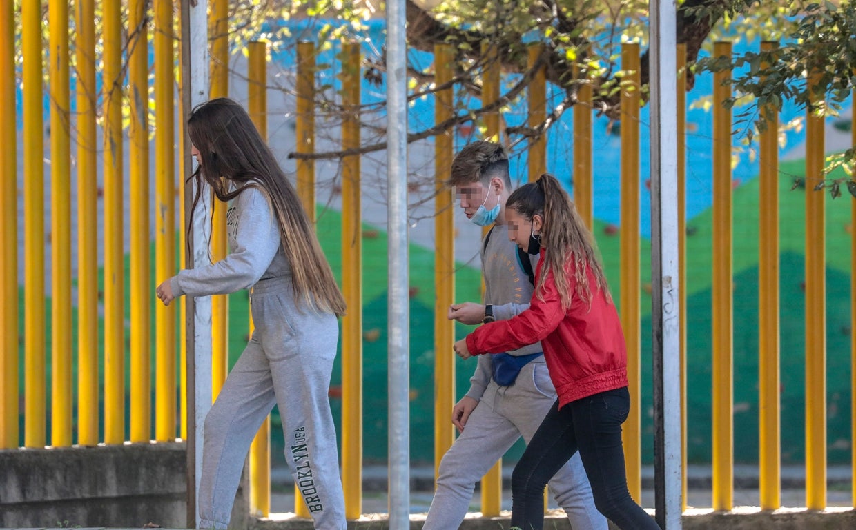 Tres jóvenes en el entorno de un colegio en la capital andaluza