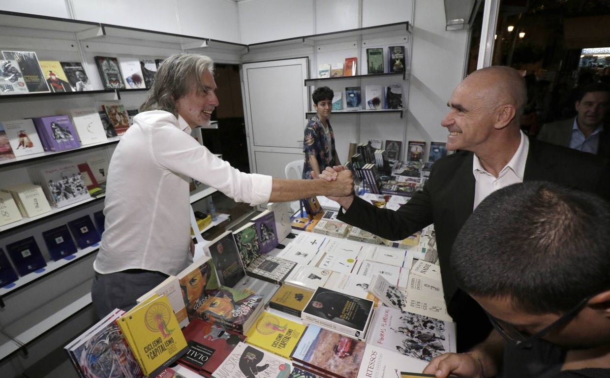 El alcalde de Sevilla, Antonio Muñoz, saluda a uno de los libreros de la Feria