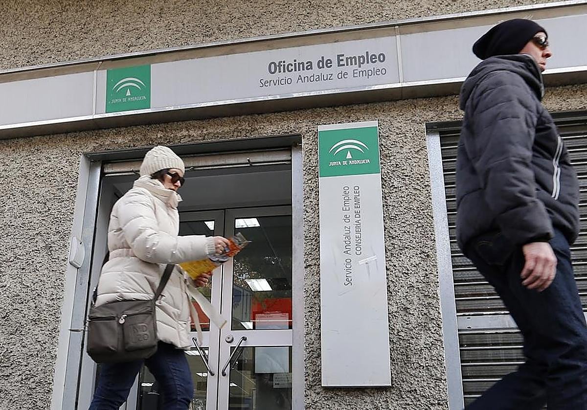 Dos personas pasan por delante de una oficina del Servicio Andaluz de Empleo