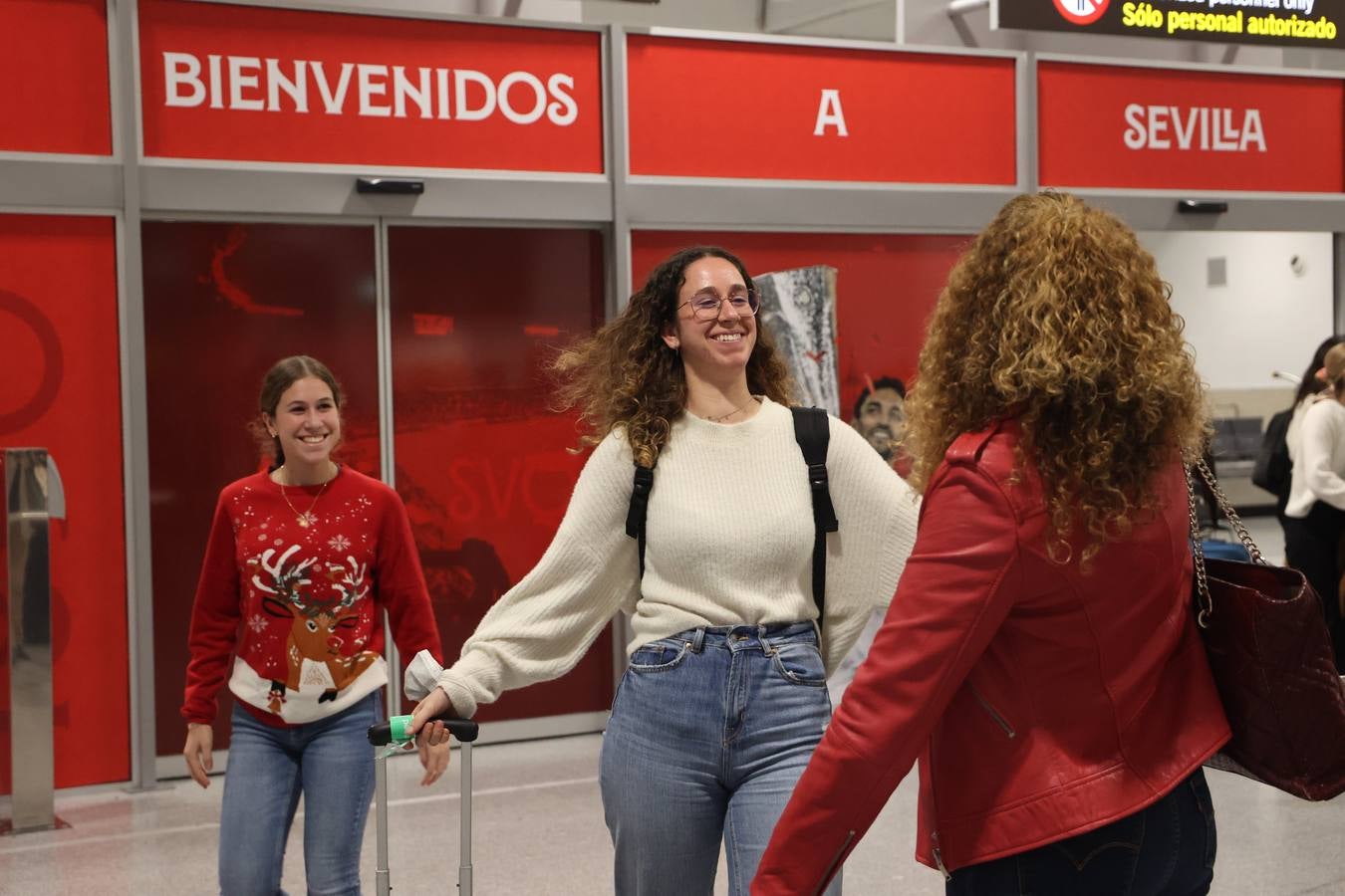 La zona de llegadas del aeropuerto sevillano se llena estos días de unos besos y abrazos muy esperados 