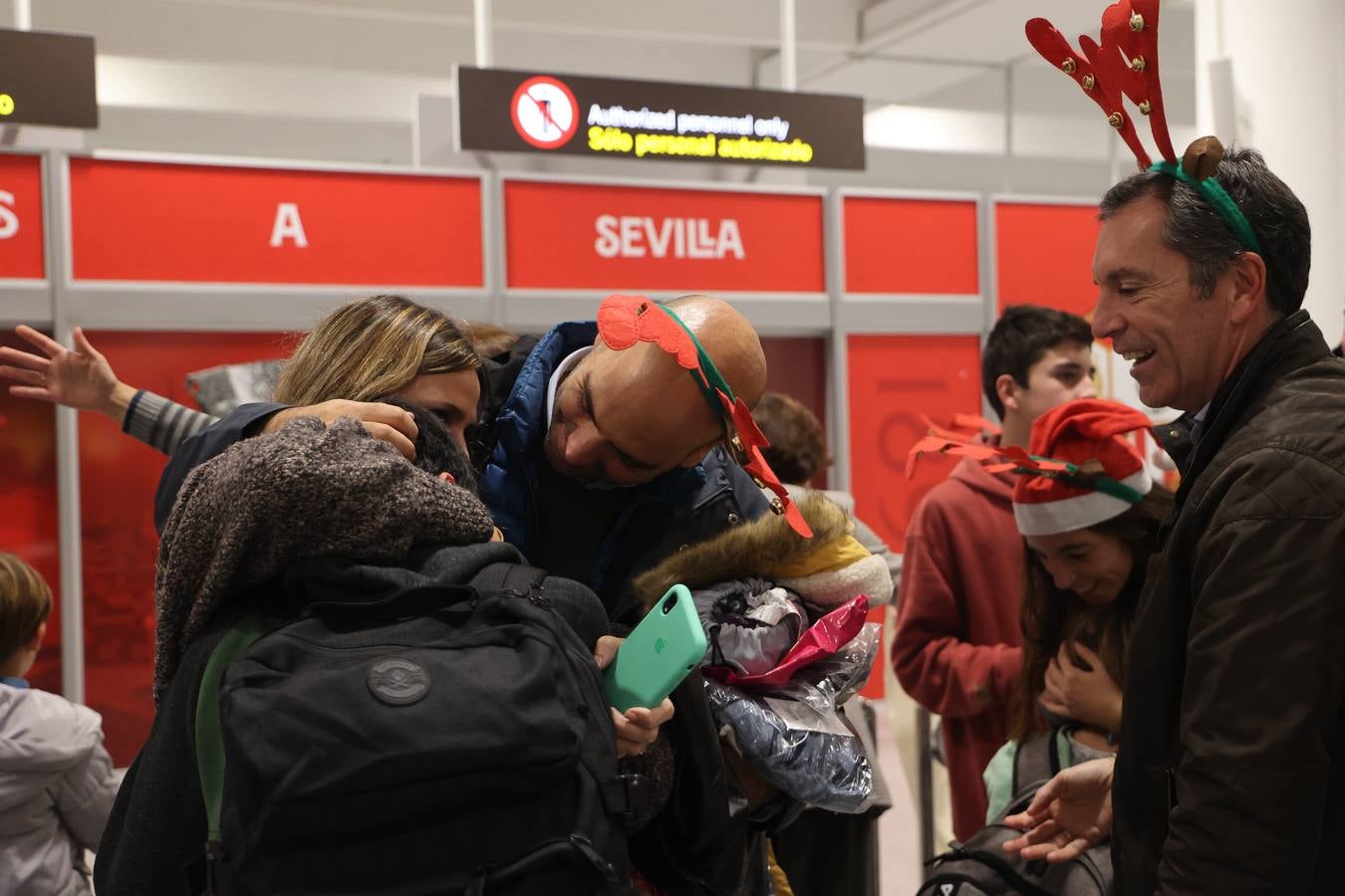 La zona de llegadas del aeropuerto sevillano se llena estos días de unos besos y abrazos muy esperados 