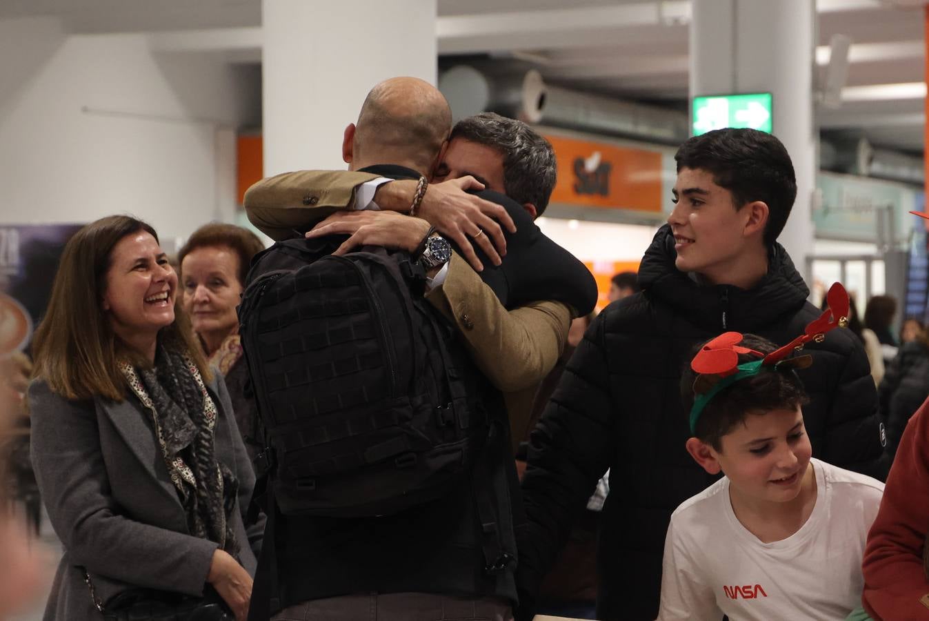 La zona de llegadas del aeropuerto sevillano se llena estos días de unos besos y abrazos muy esperados 