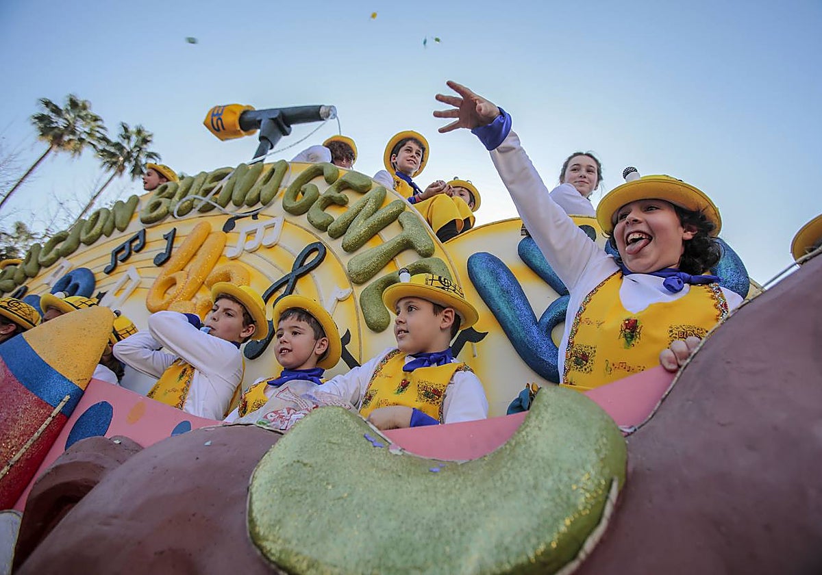 Niños lanzando caramelos desde una carroza en una foto de archivo