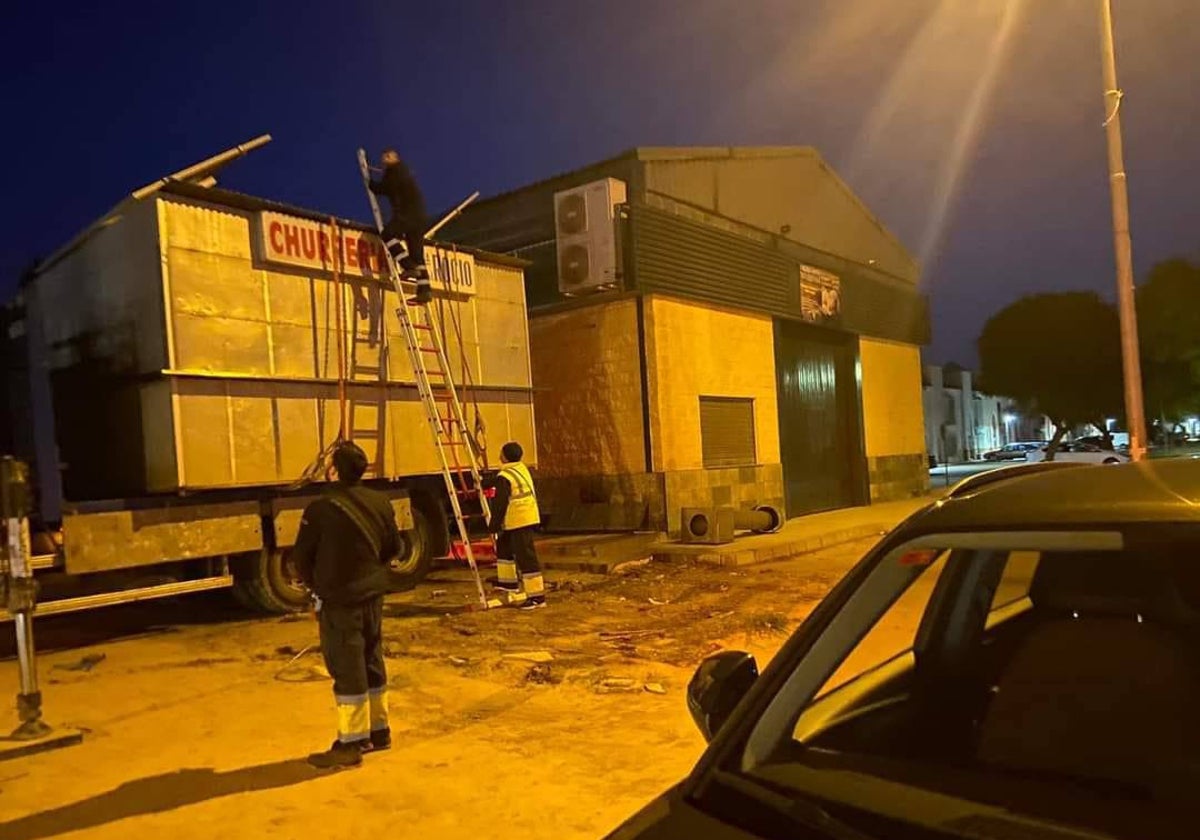 Operarios desmontan el quiosco de churros de Gelves el pasado 13 de enero