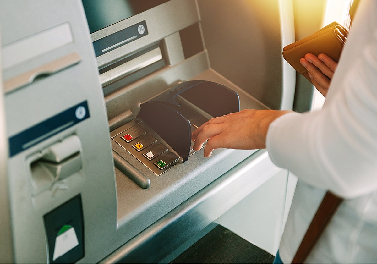 Fotografía de archivo de una mujer haciendo una operación en un cajero automático