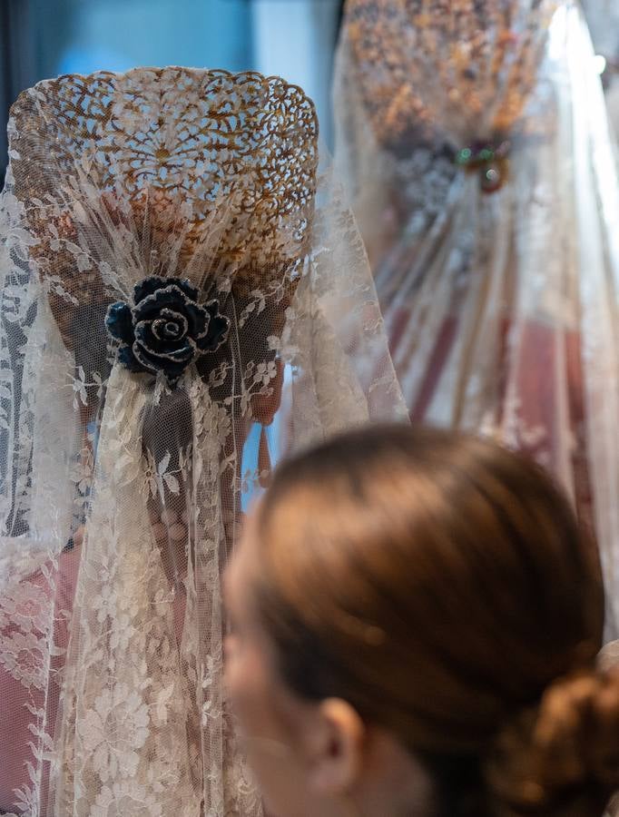 Unas jóvenes con mantilla blanca posan con la Giralda al fondo en la jornada de la Mantilla blanca