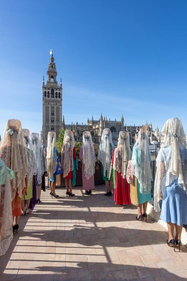 Unas jóvenes con mantilla blanca posan con la Giralda al fondo en la jornada de la Mantilla blanca