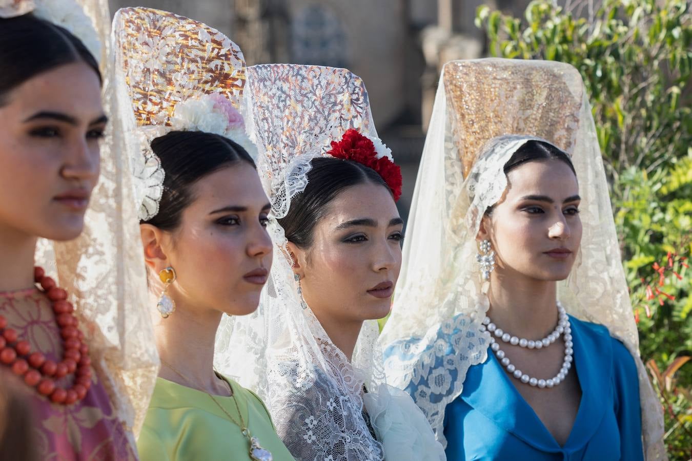 Unas jóvenes con mantilla blanca posan con la Giralda al fondo en la jornada de la Mantilla blanca