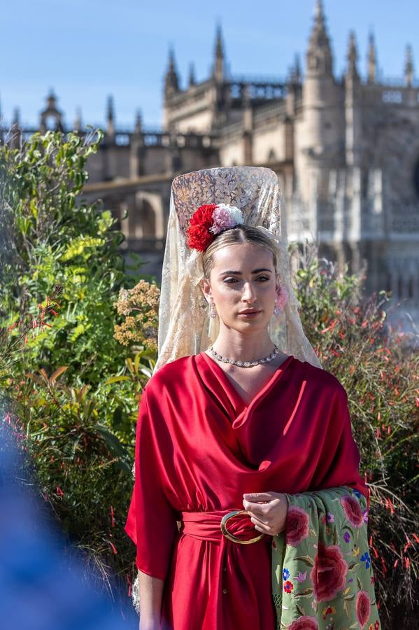 Unas jóvenes con mantilla blanca posan con la Giralda al fondo en la jornada de la Mantilla blanca