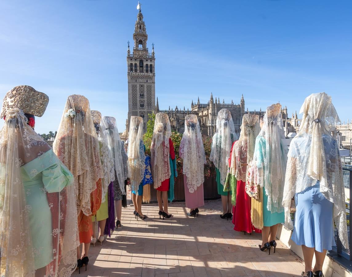 Unas jóvenes con mantilla blanca posan con la Giralda al fondo en la jornada de la Mantilla blanca