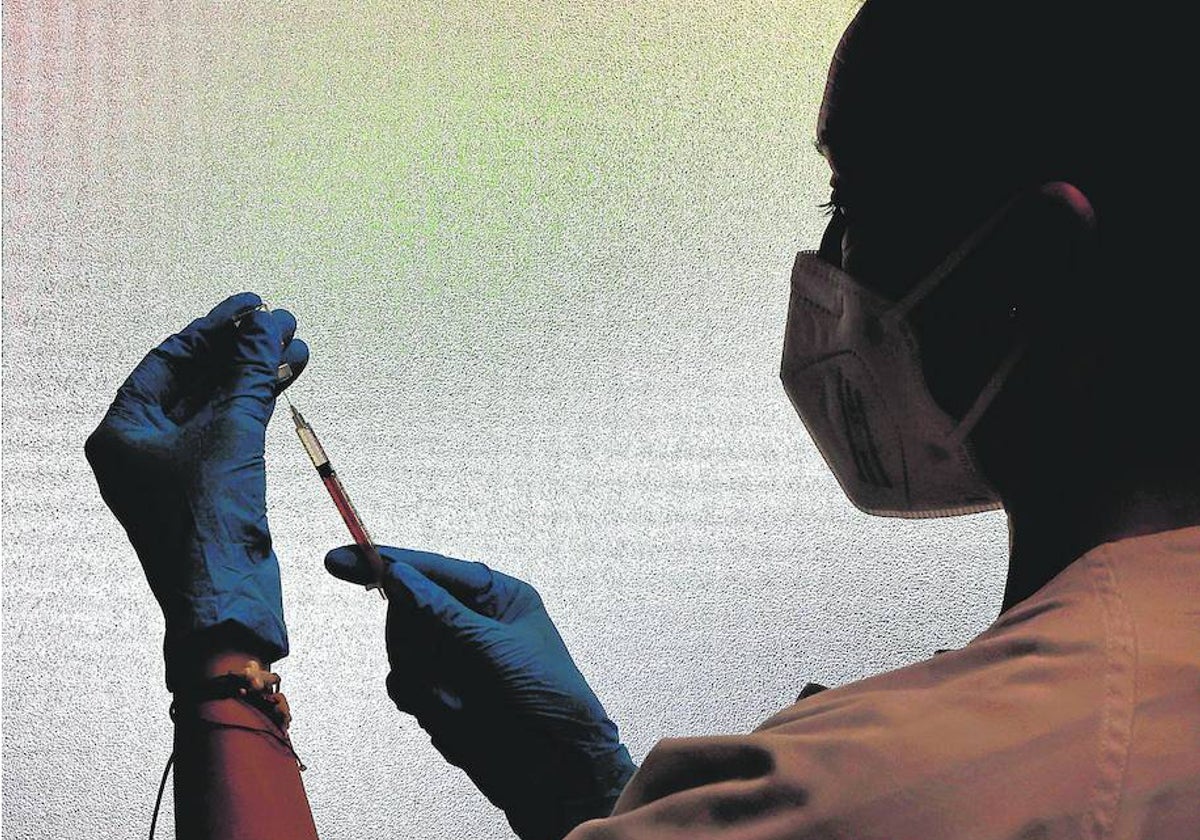 Una enfermera antes de administrar una vacuna contra el Covid