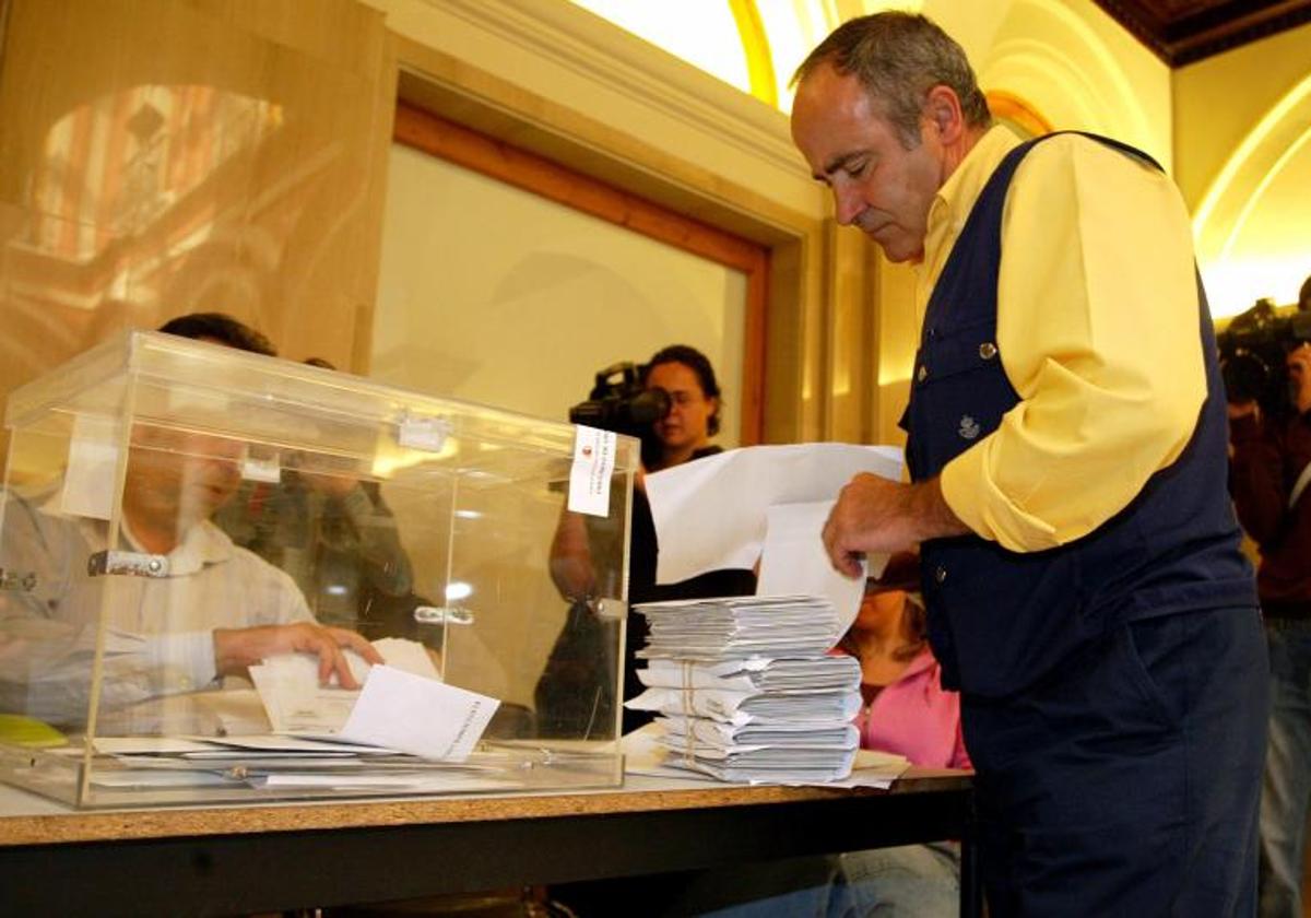 Un cartero lleva el voto por correo a una mesa electoral