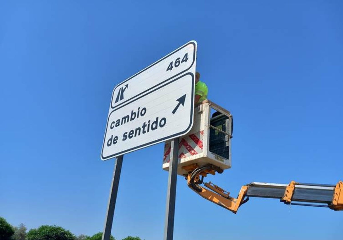 Un operario revisa un cartel en una carretera