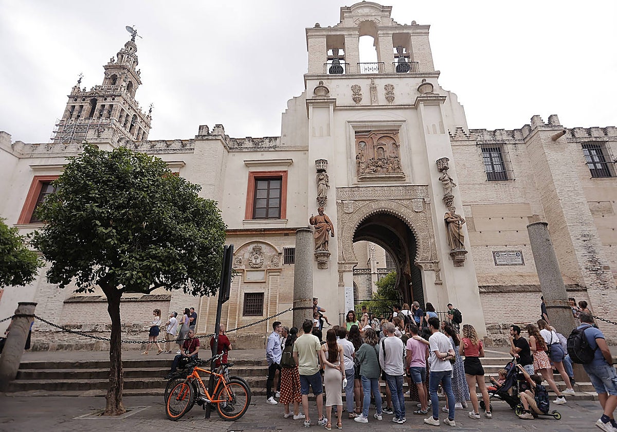Un grupo de turistas en la calle Alemanes, junto a la puerta del Patio de los Naranjos de la Catedral