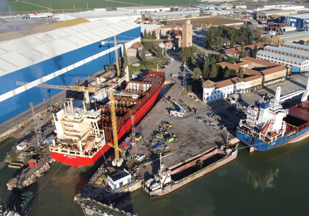 El carguero pintado de color rojo está siendo reparado en el dique de Astilleros del Guadalquivir