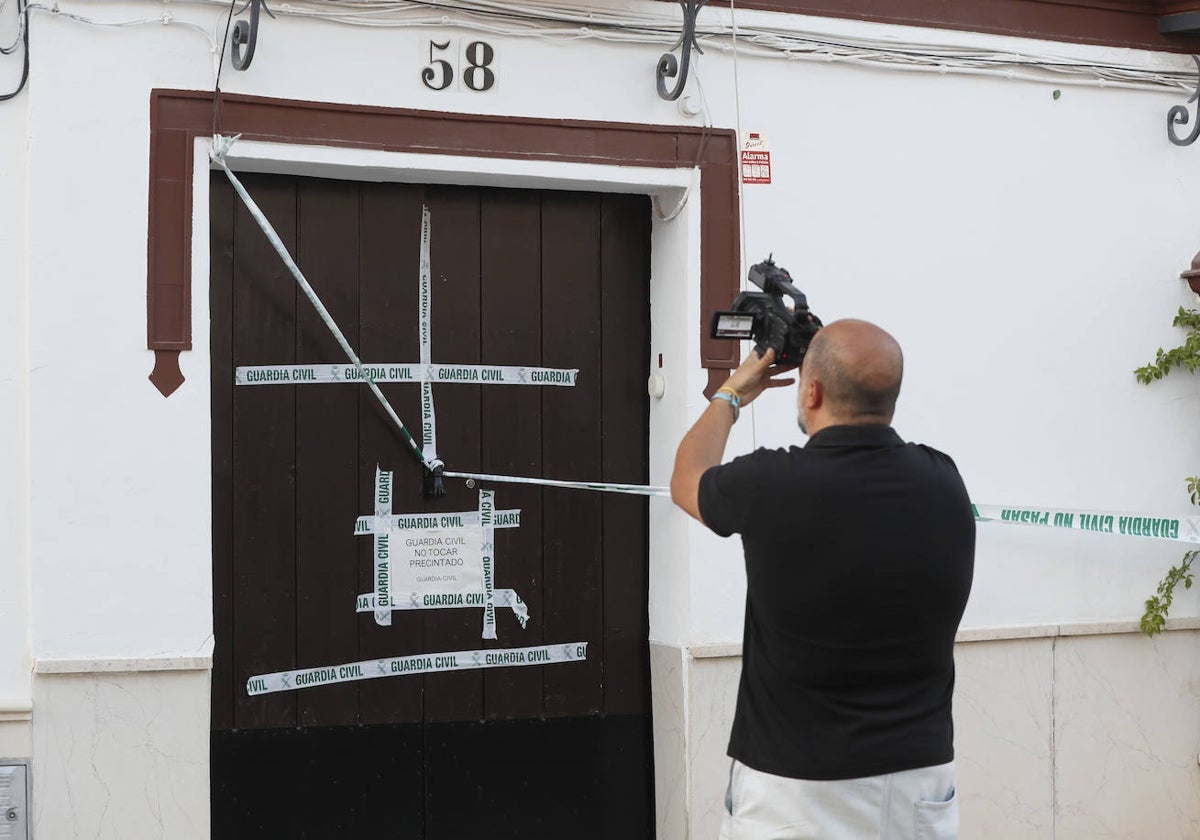 Un cámara de televisión graba la fachada de la vivienda donde fueron localizados los cadáveres