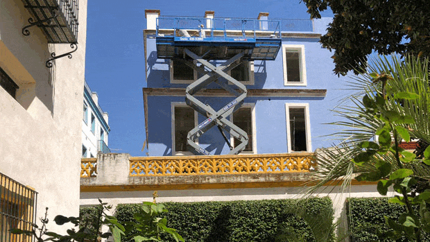 El edificio pintado de celeste se eleva sobre la tapia del Jardín Chico de la Casa de Pilatos de Sevilla