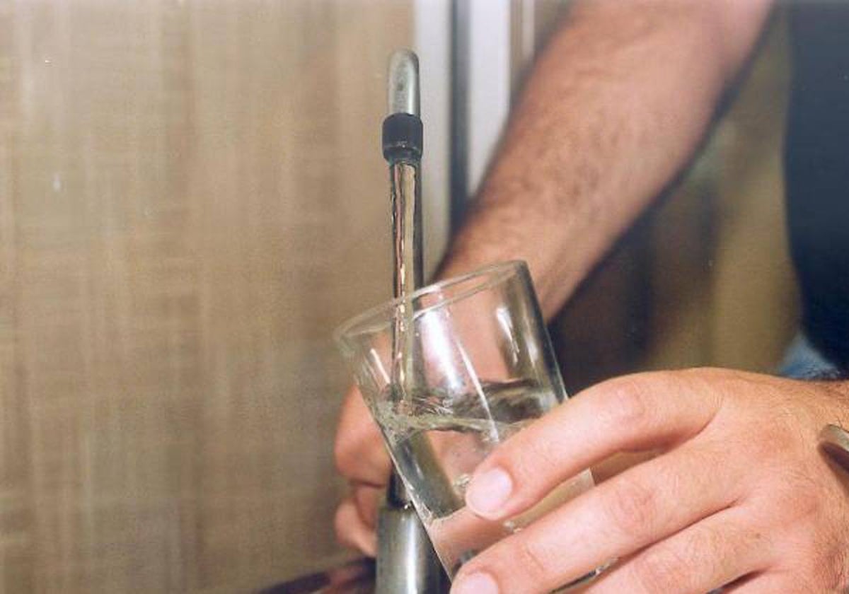 Una persona llena un vaso de agua