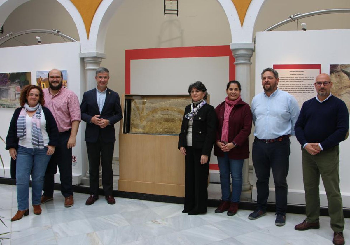 Representantes políticos y arqueólogos junto al muro de adobe